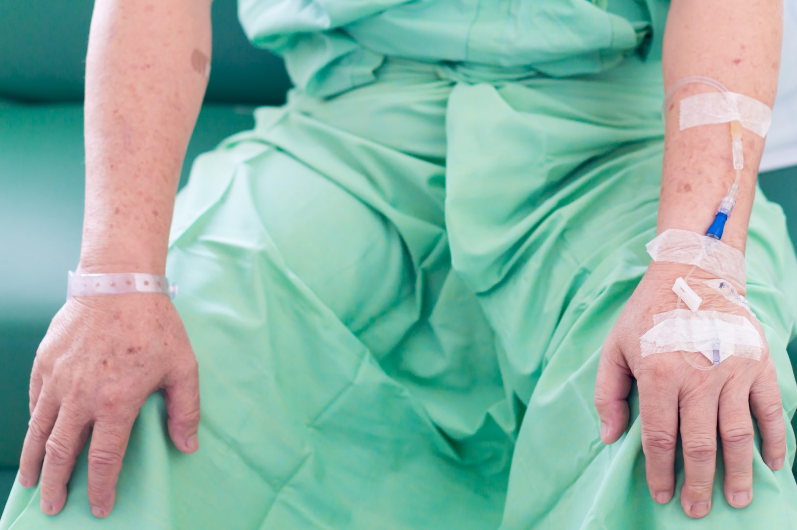 Onderlichaam en handen man in groene medische kledij